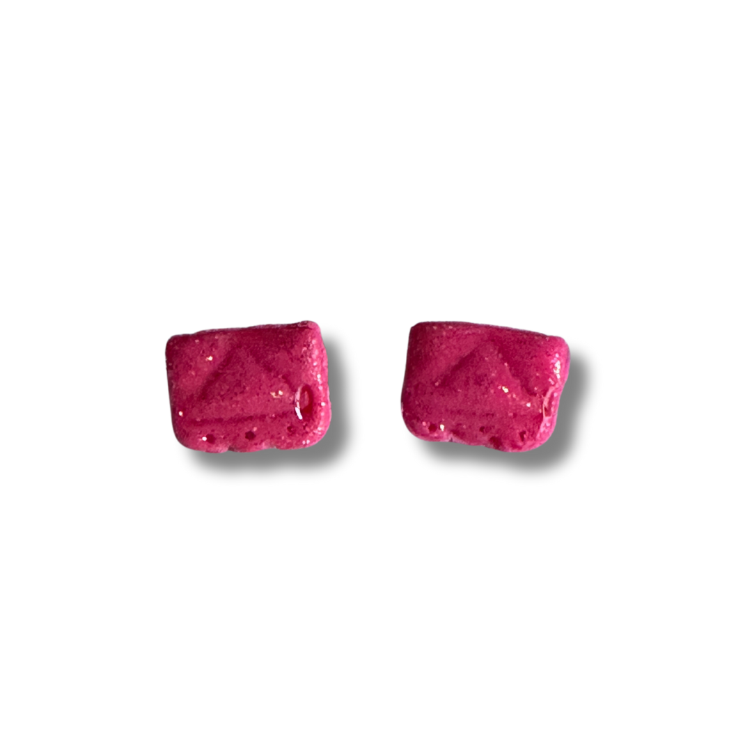 A zoomed in image of a pair of hot pink Alamo earring studs on a white background.
