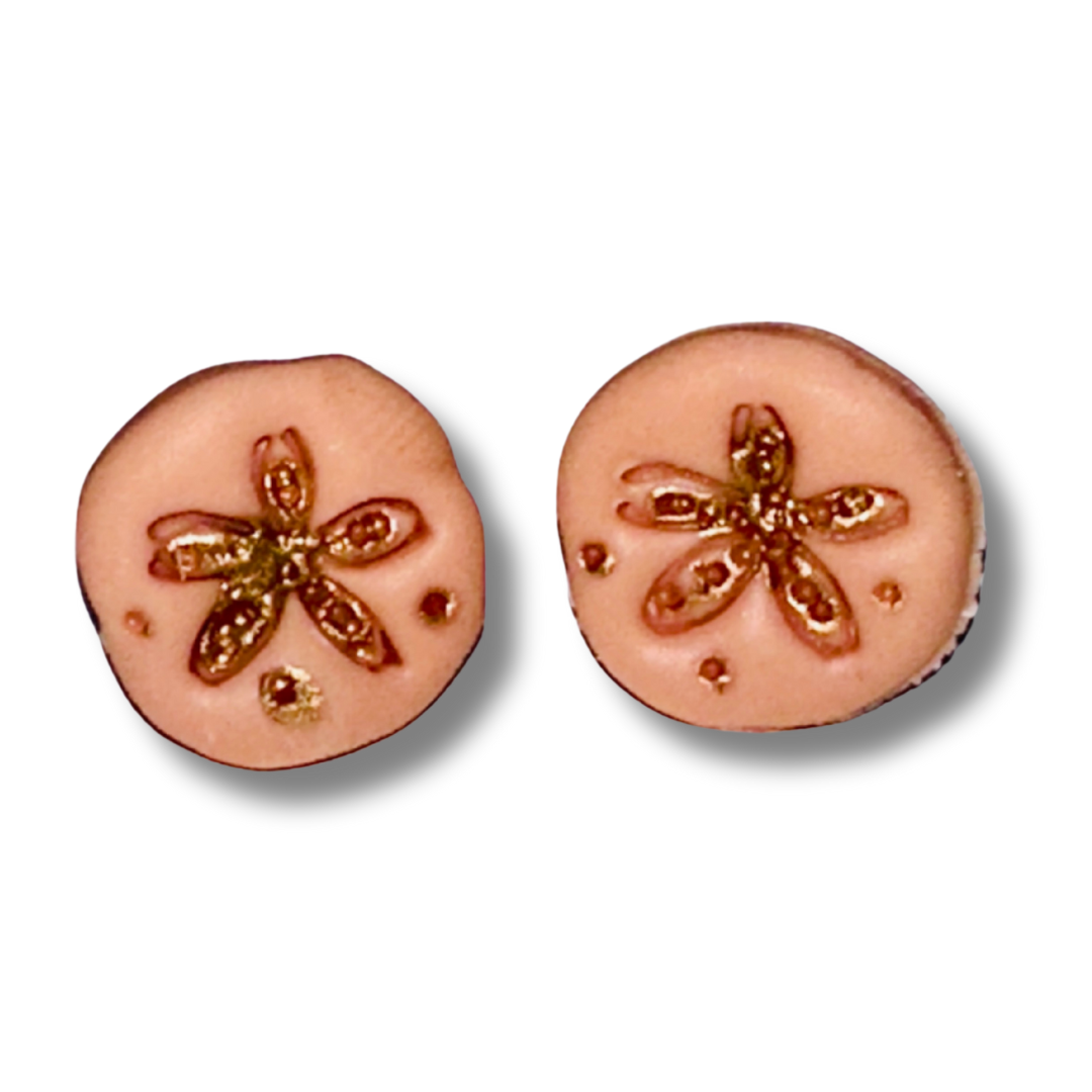 Detailed view of peach sand dollar stud earrings highlighting handmade polymer clay craftsmanship and beach-inspired design.