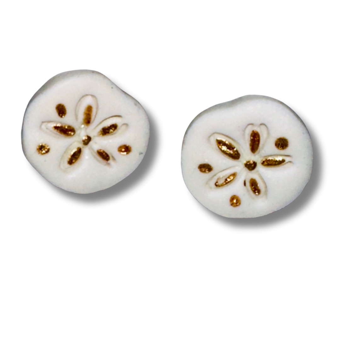 Close-up view of white sand dollar stud earrings showing handcrafted polymer clay texture and detail.
